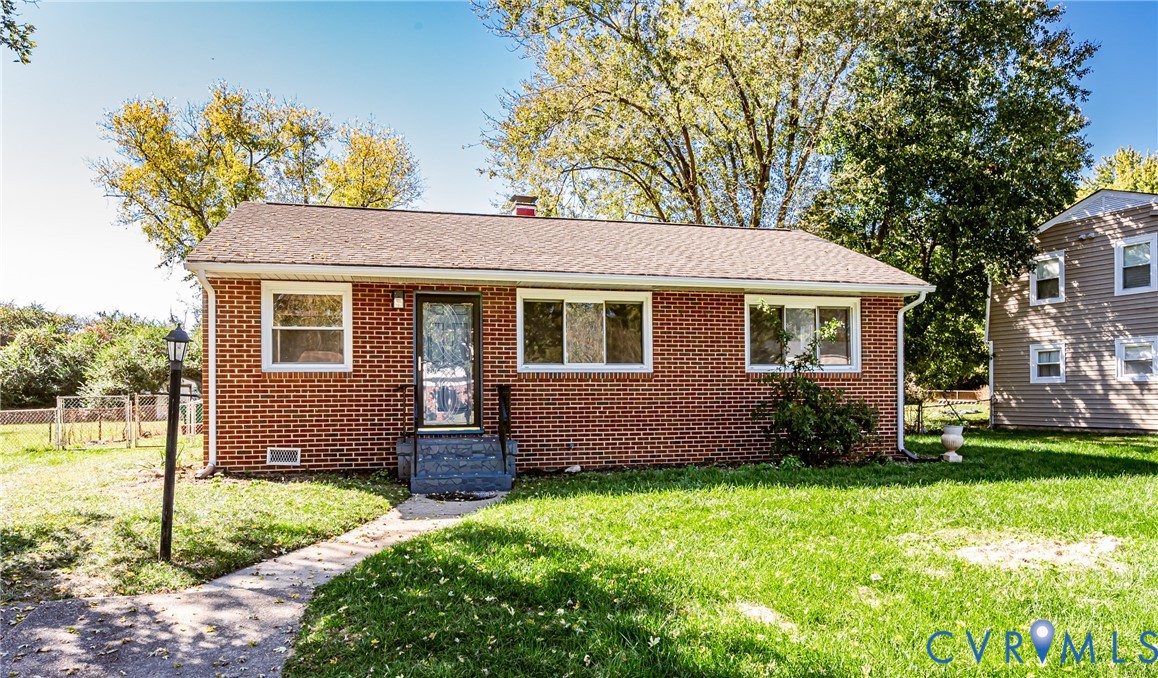 Single-story brick exterior with a gable roof, integrated chimney, multi-pane windows, and a paved walkway