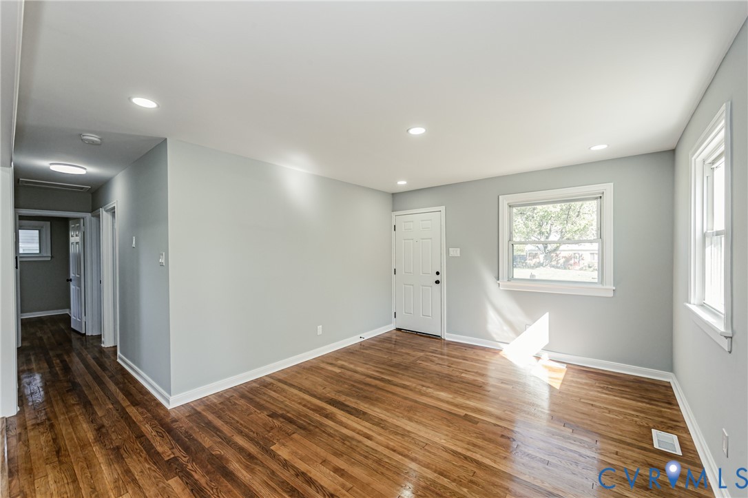 Interior space featuring wood-finish flooring, recessed lighting, and a six-panel entry door
