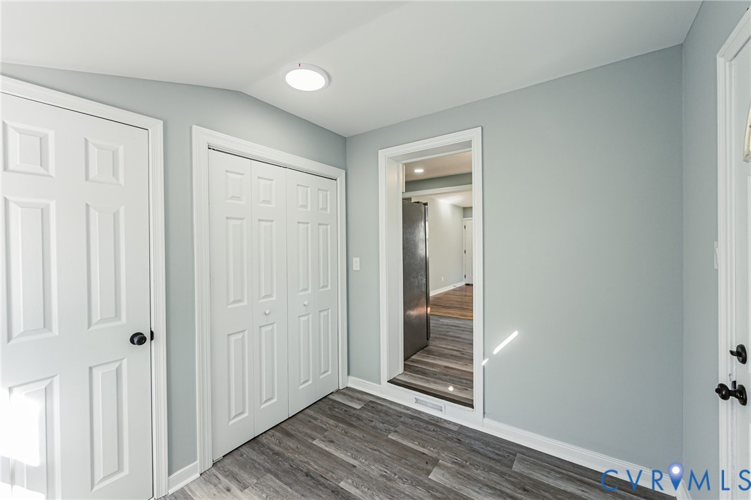 Interior space featuring wood-finish flooring, double-panel closet doors, and a flush-mount circular ceiling light fixture