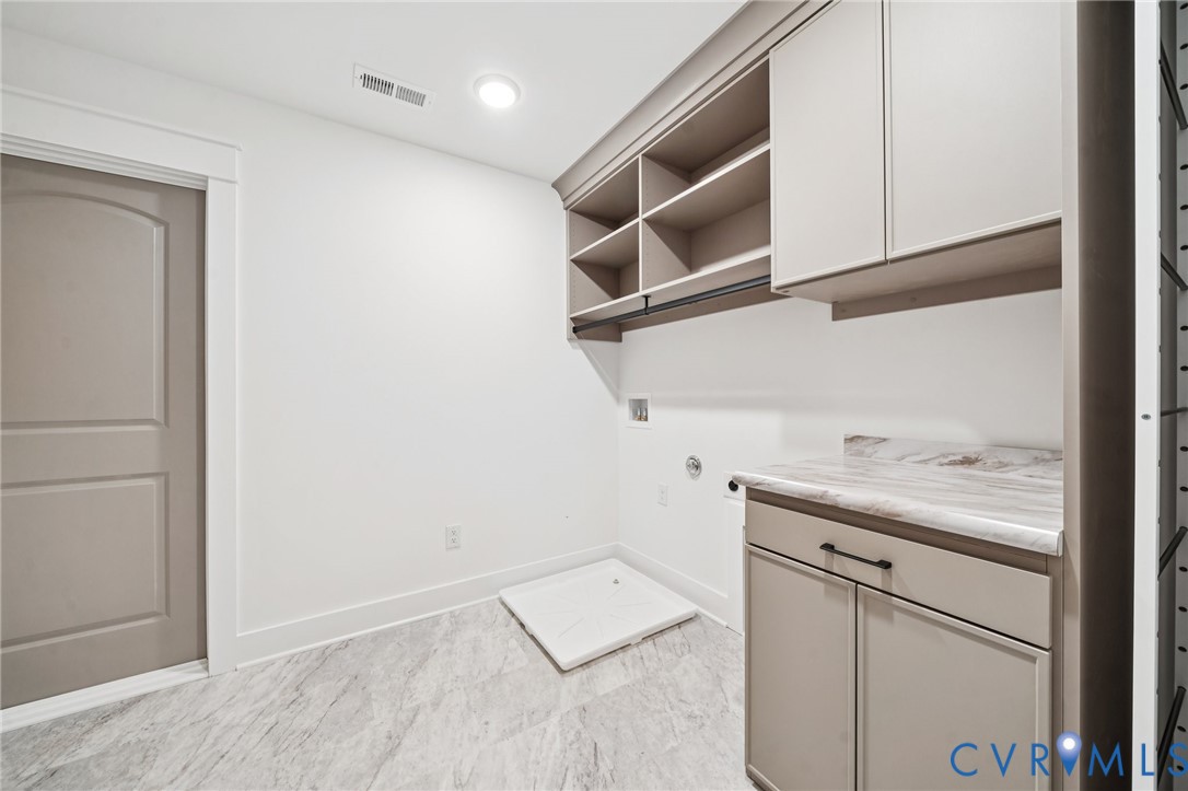Utility room featuring custom cabinetry with open shelving, laminate countertop, recessed lighting, and tile flooring