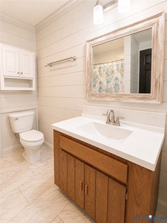 Wood-finish cabinetry with white countertop, integrated sink, horizontally paneled walls, wall-mounted storage cabinet, and tile flooring