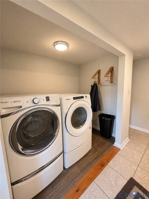 Laundry area featuring wood-finish flooring, tile flooring transition, and ceiling-mounted lighting