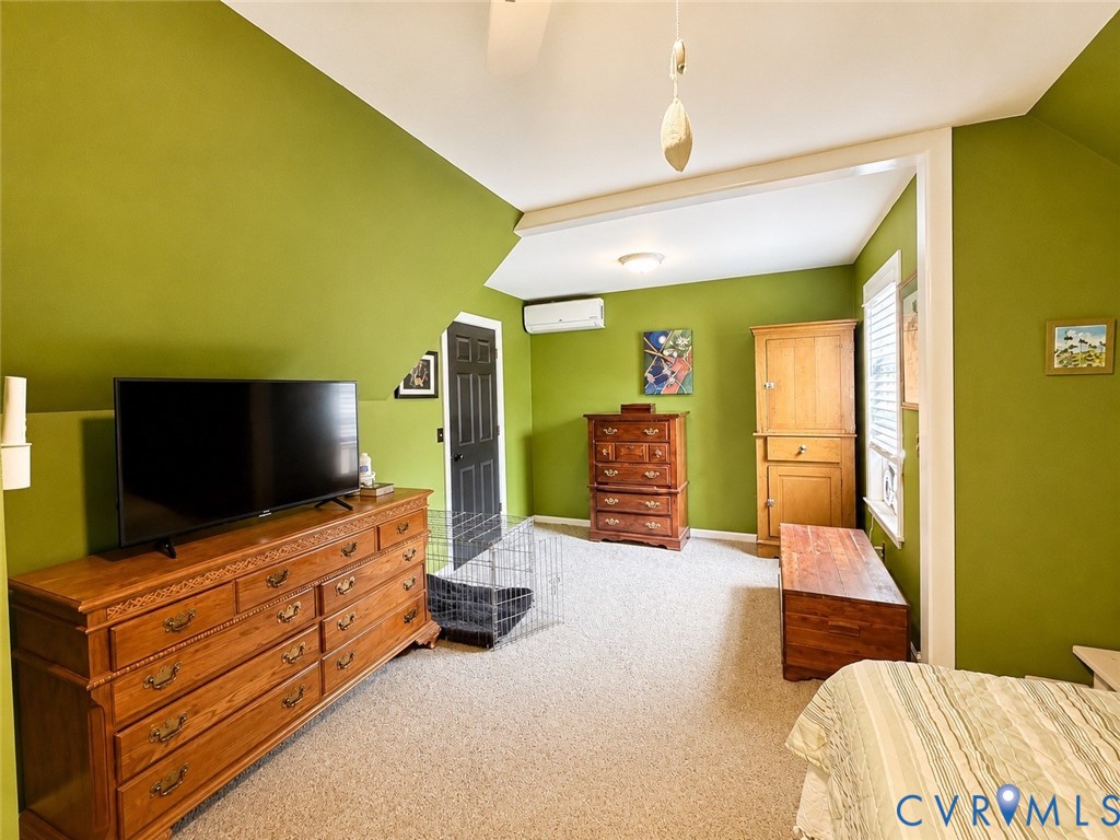 Room featuring a ductless mini-split climate control system, carpeted flooring, and a window with horizontal blinds