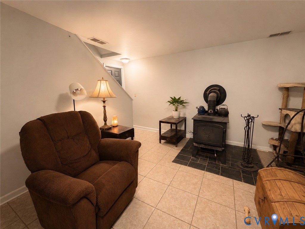 Cast iron wood-burning stove set upon a dark tile hearth with ceramic tile flooring