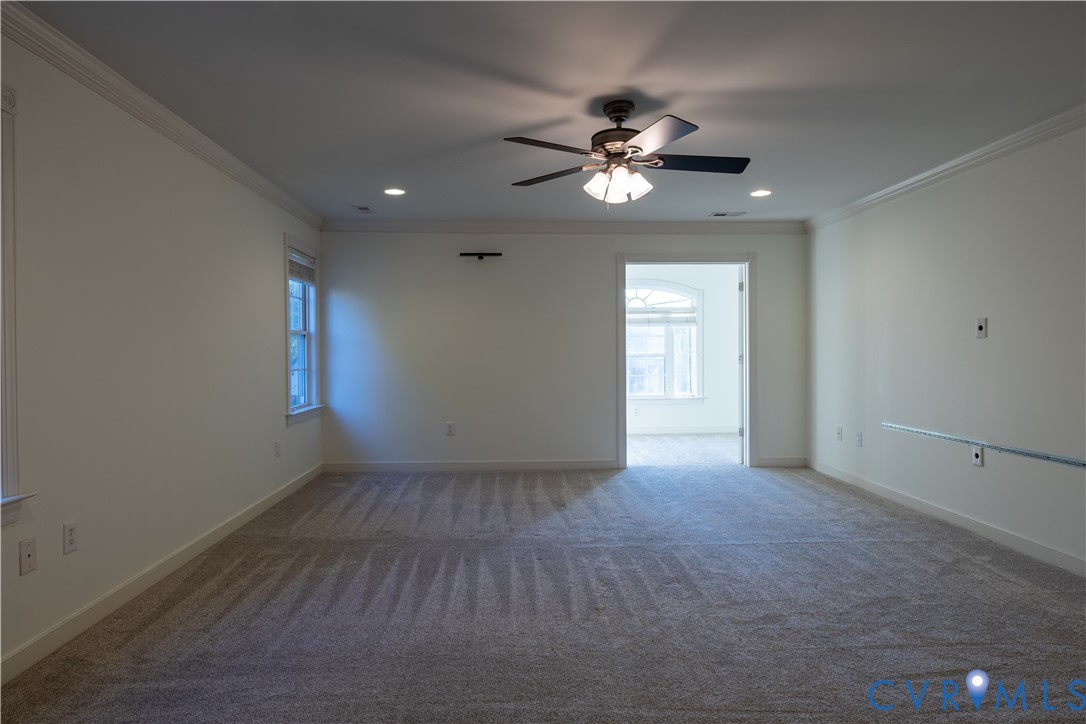 Neutral-toned carpeting, ceiling-mounted paddle fan with integrated lighting, recessed ceiling lighting, and crown molding