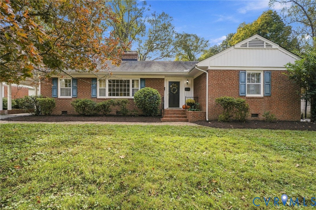 Traditional brick exterior featuring white paneled shutters, a chimney, and a gable roofline with decorative siding