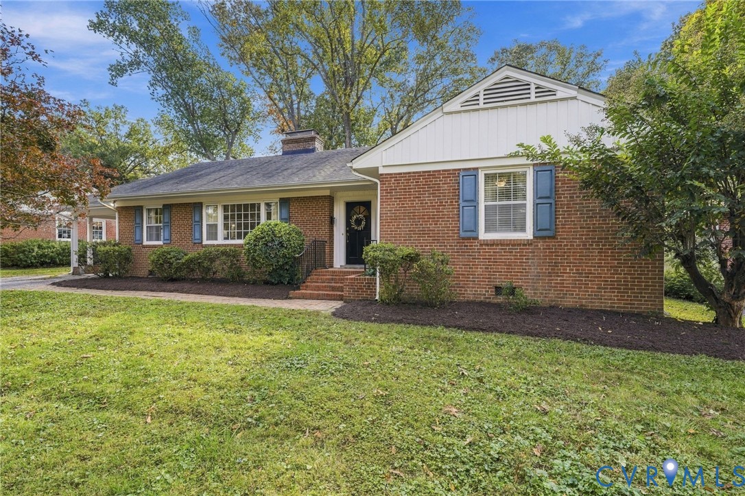 Traditional brick exterior featuring white vertical siding accents, dark-toned shutters, a multi-pane grid window, and a brick front entry staircase