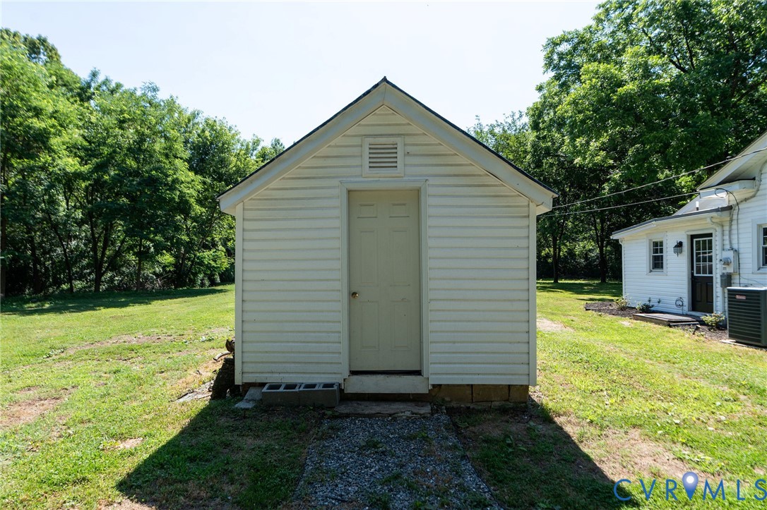 Detached storage structure featuring horizontal siding, a gabled roof, and a single-entry door