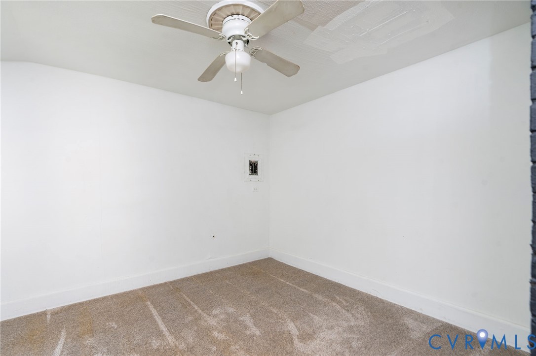 Interior room featuring neutral wall paint, wall-to-wall carpeting, and a central ceiling fan with an integrated light fixture