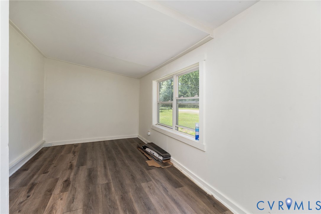 Neutral-toned interior space featuring wood-finish flooring and a multi-pane window