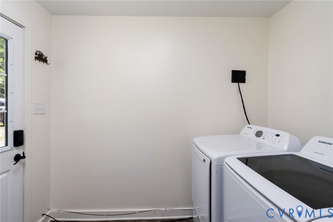 Utility area featuring a side-exit door with a glass pane, wood-finish flooring, and built-in laundry appliance connections