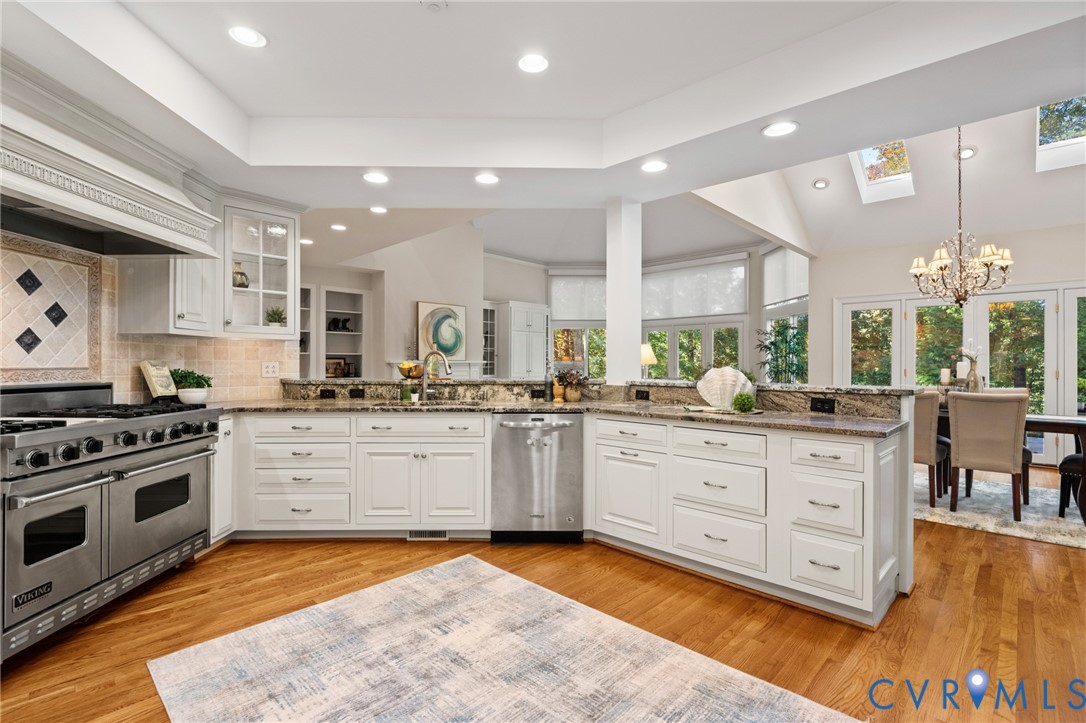 Kitchen featuring white cabinetry, stone countertops, stainless steel professional-grade range, recessed lighting, and wood-finish flooring
