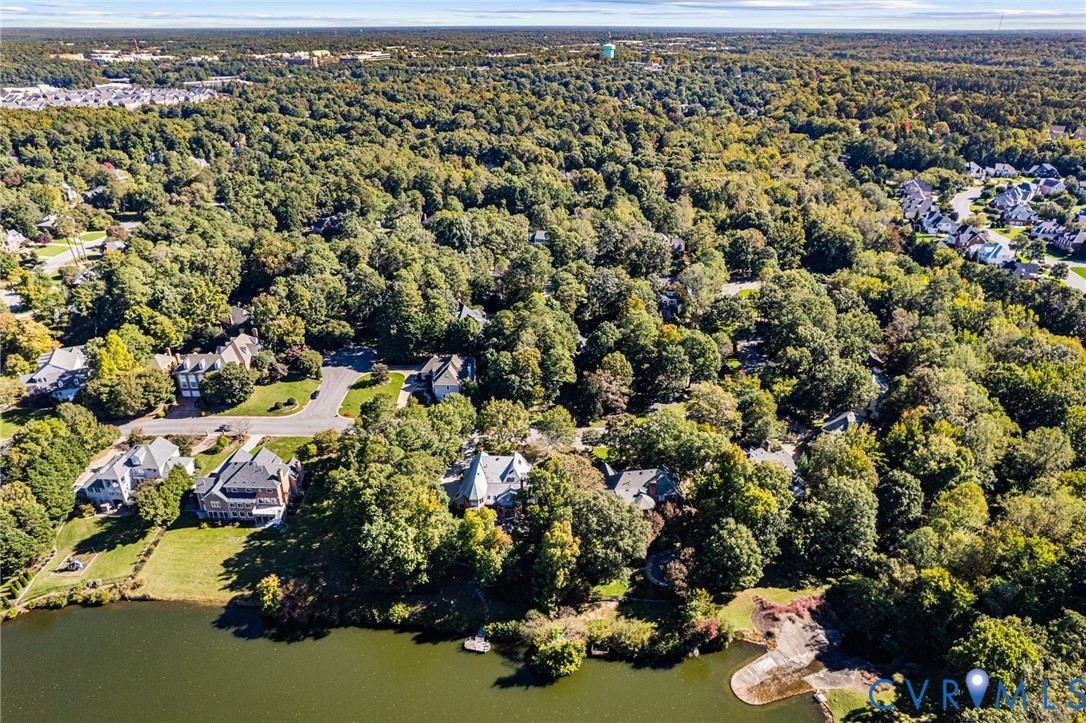 Aerial perspective of waterfront properties featuring extensive mature canopy, paved cul-de-sac streets, and direct shoreline access