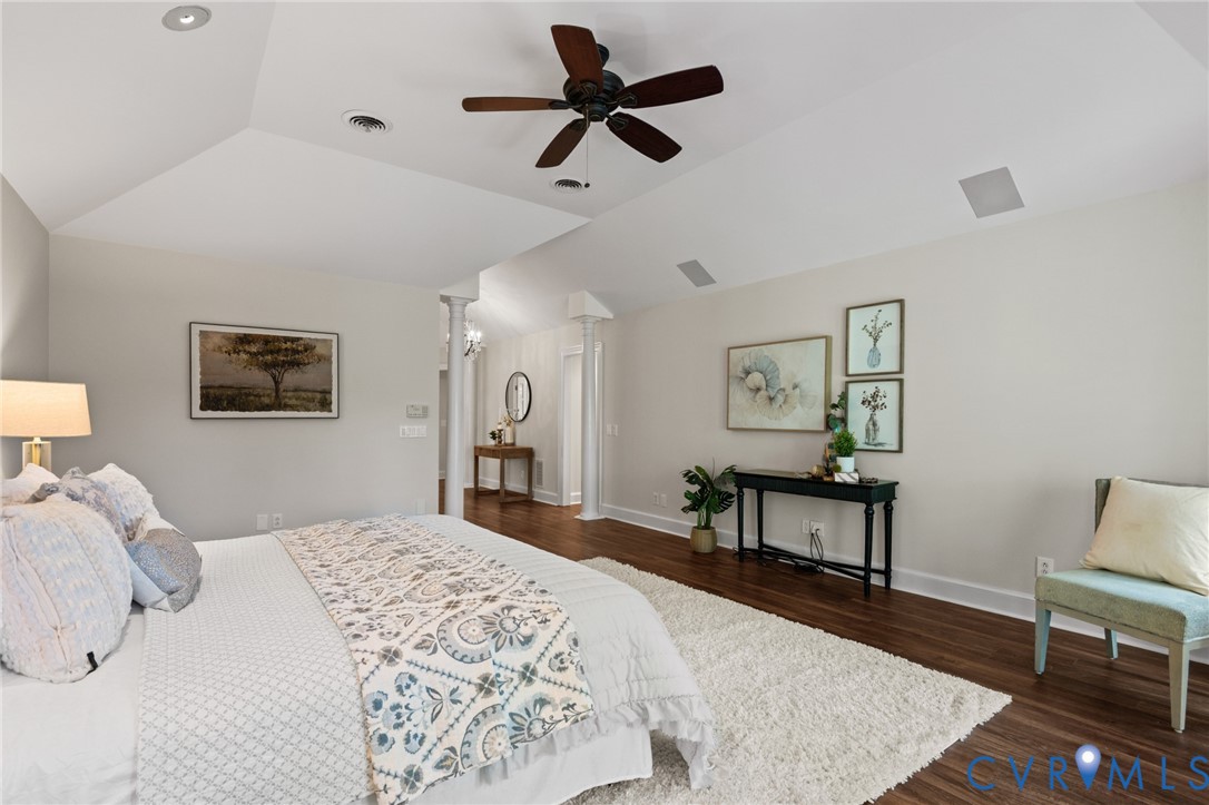 Vaulted ceilings with recessed lighting, wood-finish flooring, and structural columns