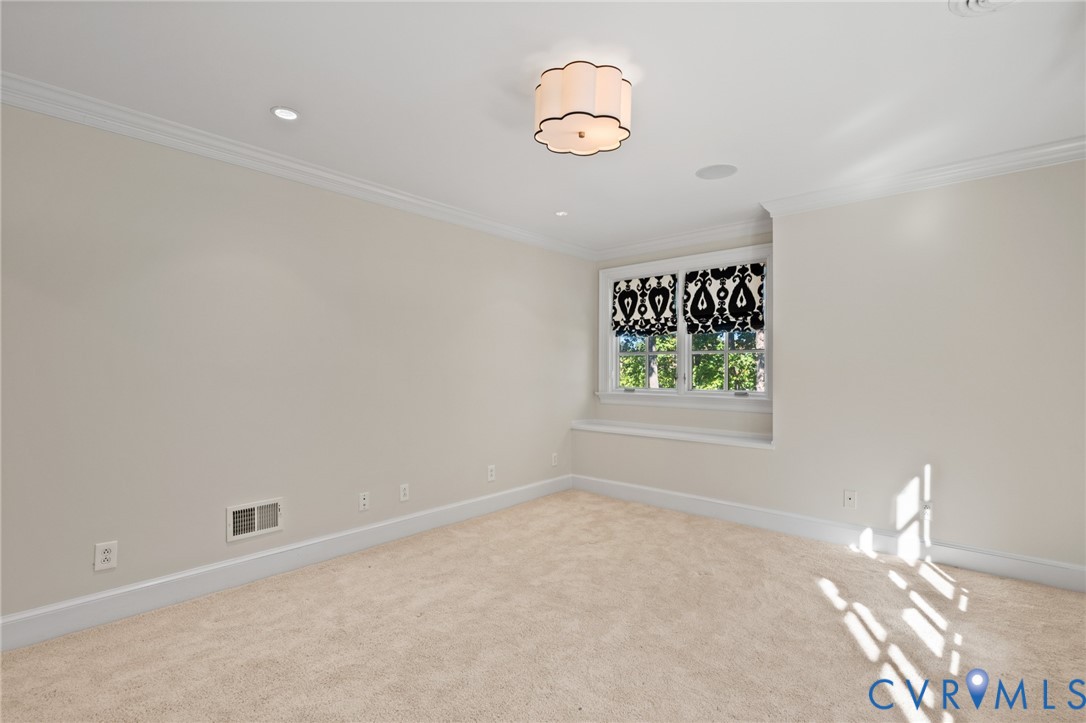 Neutral interior featuring crown molding, recessed lighting, a decorative drum ceiling fixture, and a window seat with multi-pane window