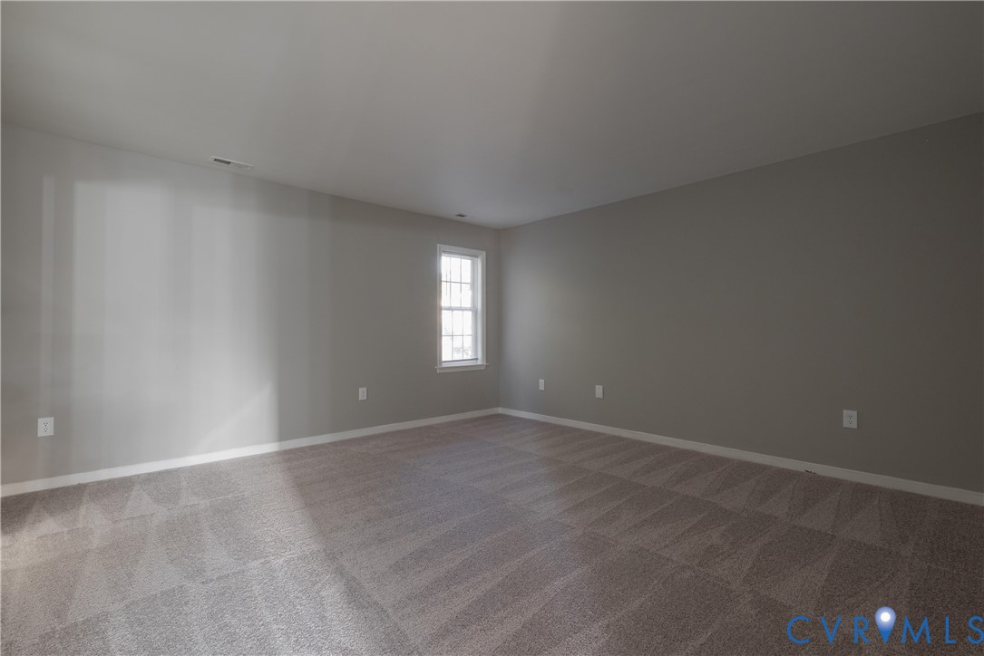 Primary Bedroom with Neutral-toned interior space featuring wall-to-wall carpeting and a single-pane grid window