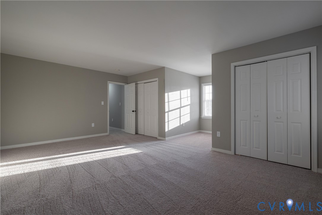 Bedroom #4 with Neutral wall tones, wall-to-wall carpeting, and dual bi-fold door closets