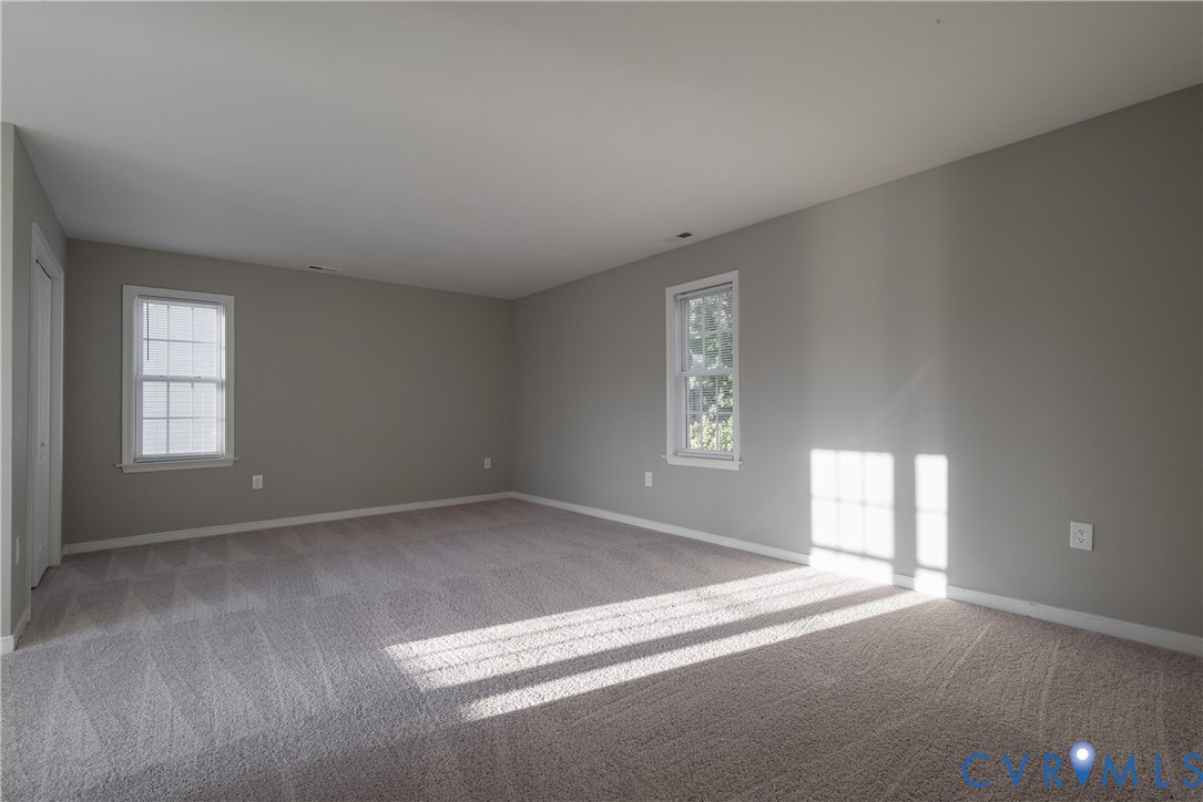 Bedroom #4 with Neutral-toned interior space featuring wall-to-wall carpeting and double-hung windows with white trim