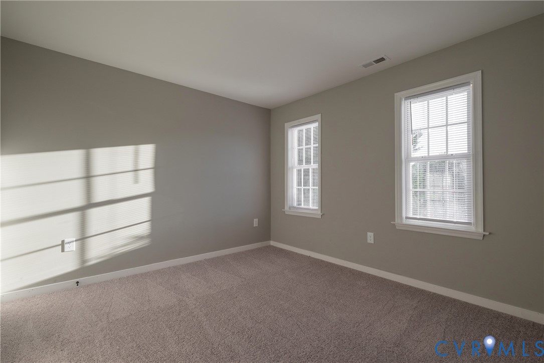 Bedroom #2 Room featuring neutral-toned walls, carpeting, and two double-hung windows with white trim