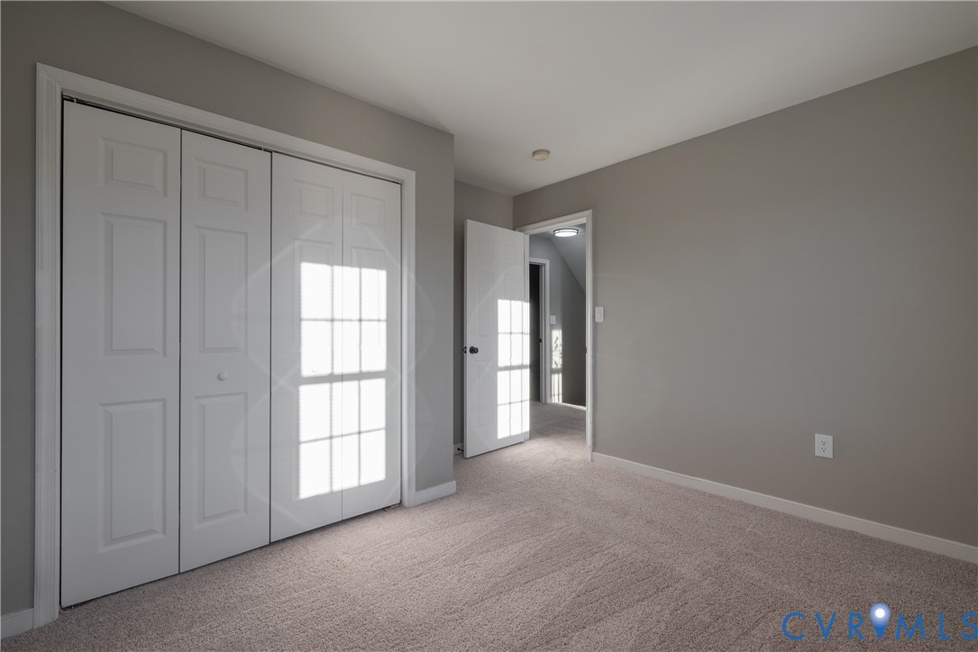 Bedroom #3 with neutral interior with wall-to-wall carpeting, bi-fold closet doors featuring a multi-pane design, and a solid-core interior door