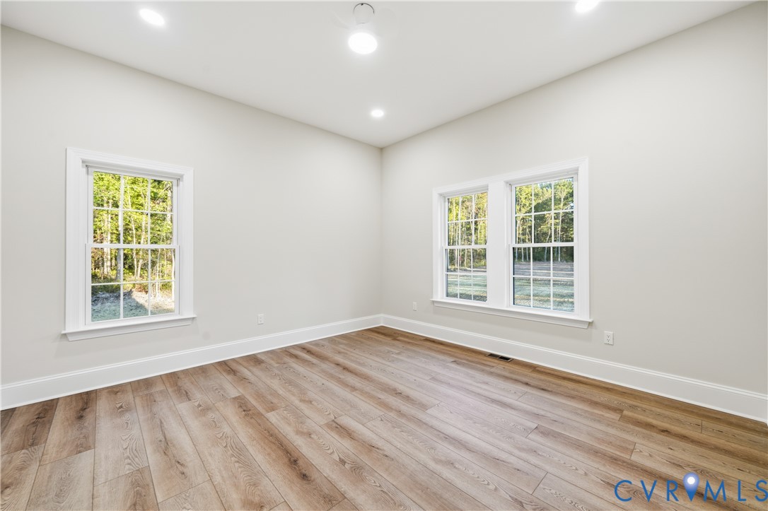 Neutral interior featuring wood-finish flooring, recessed lighting, and multi-pane windows