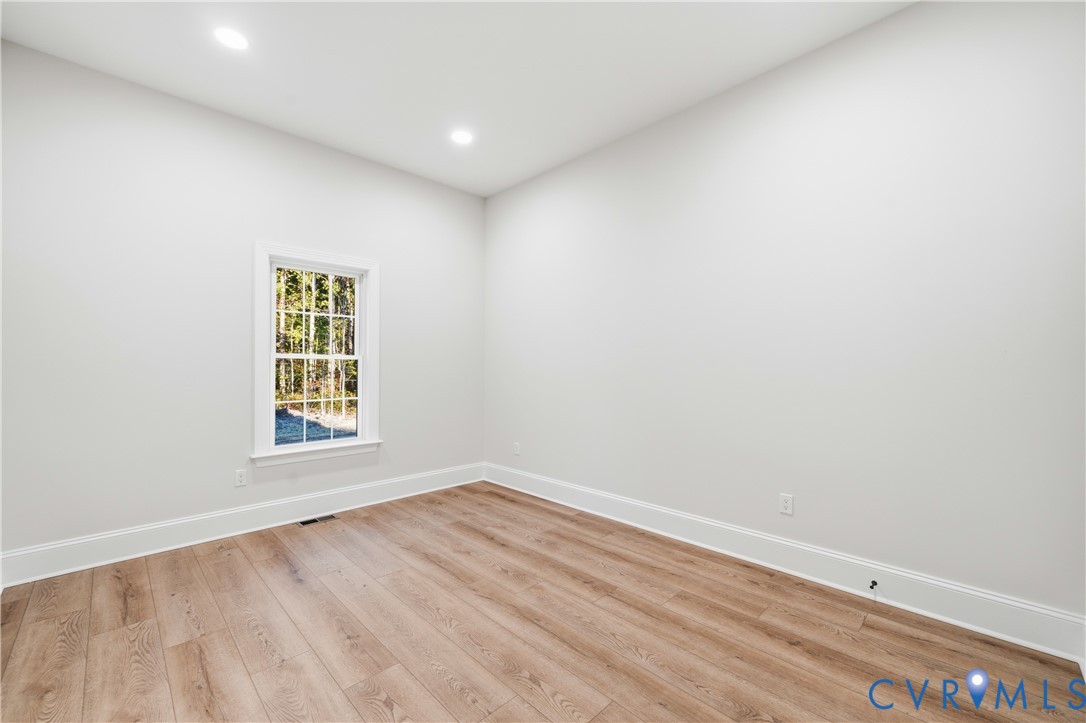 Neutral-toned interior featuring wood-finish flooring, recessed lighting, and a single-hung window
