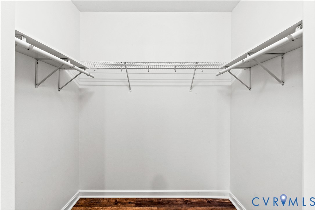 Walk-in storage area featuring wood-finish flooring and tiered wire shelving systems