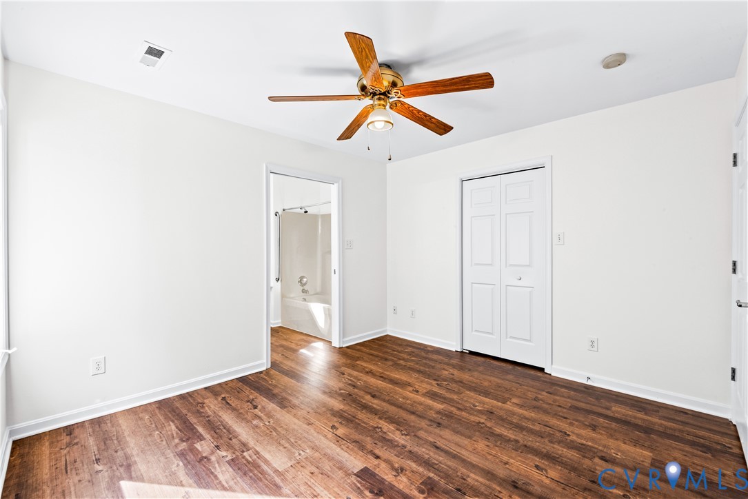 Wood-finish flooring, ceiling fan with integrated lighting, and bifold closet doors