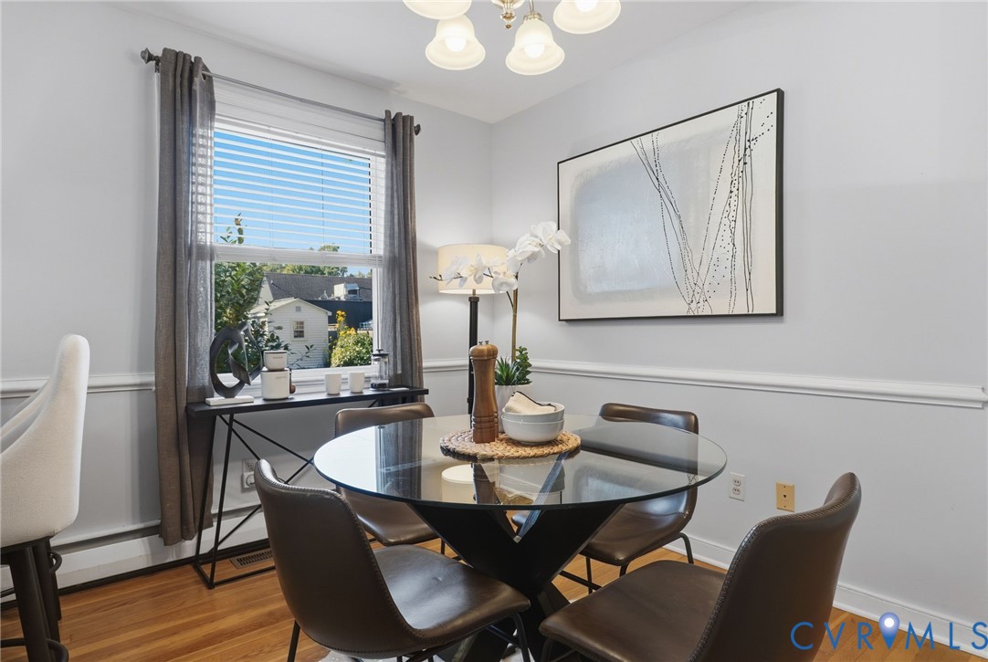 Wood-finish flooring, chair rail molding, and a five-light chandelier
