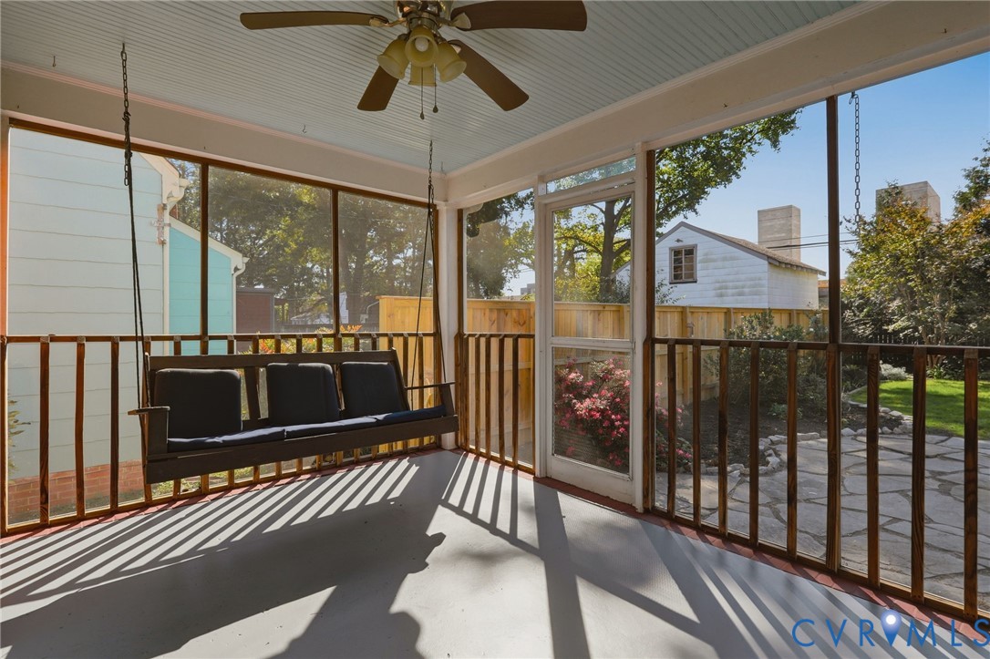 Screened-in porch featuring a painted beadboard ceiling, ceiling fan, and wooden railing