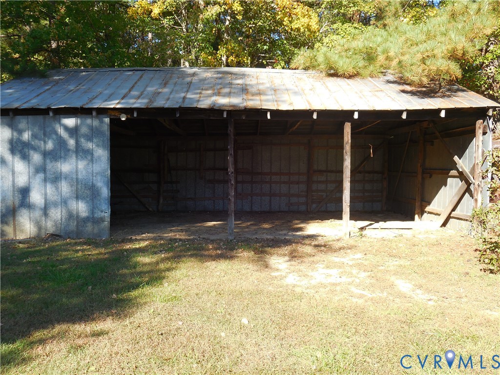 Open-air structure featuring metal siding, a corrugated metal roof, and post-and-beam construction