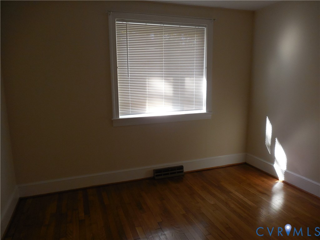 Hardwood flooring and a central window with classic casing