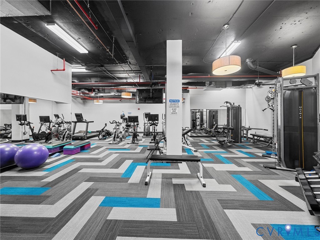 Ample gym with cardio equipment and weights.