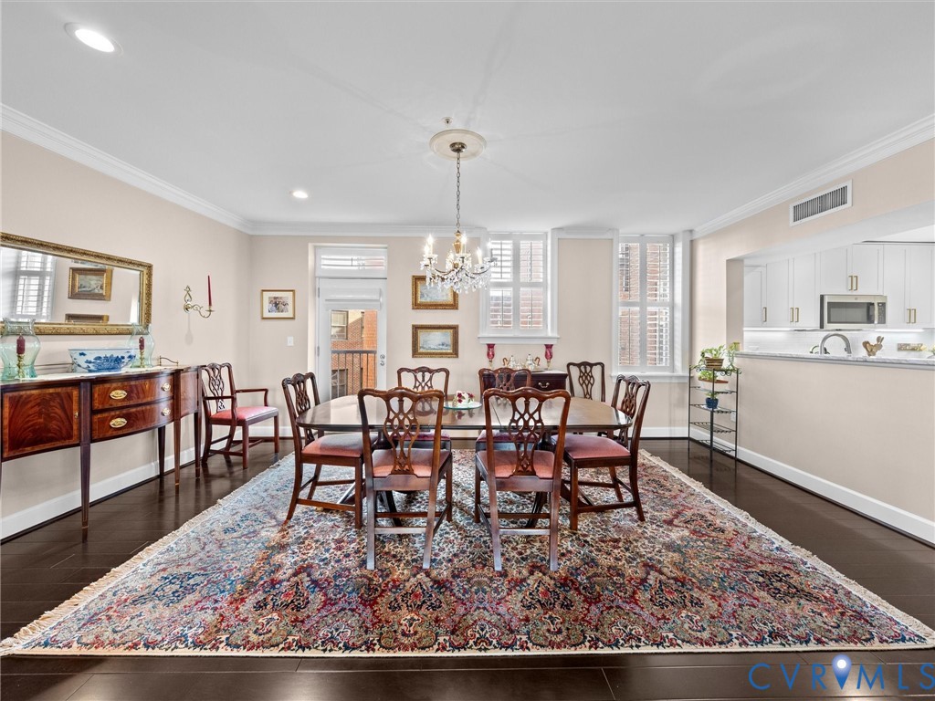 View of dining room which is open to kitchen. Door opens to a Juliet balcony overlooking the historic central courtyard. View of dining room which is open to kitchen. Door opens to a Juliet balcony overlooking the historic central courtyard.
