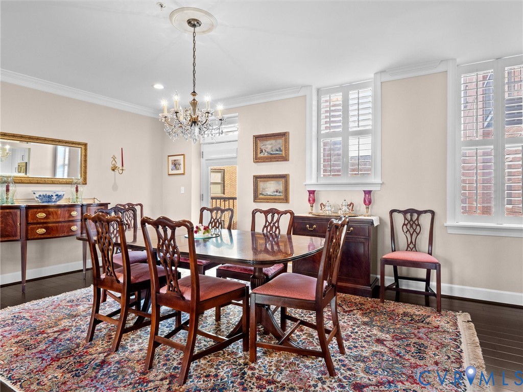 Dining room has crown moulding and plantation shutters.