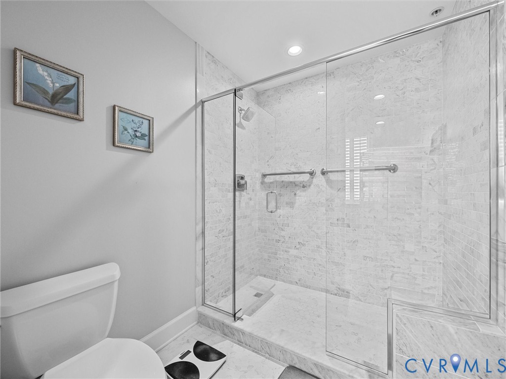 Marble tiled shower with low threshold.