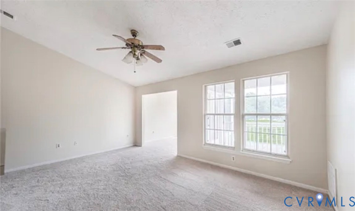 Vaulted ceiling with a centrally mounted ceiling fan, neutral wall tones, wall-to-wall carpeting, and double-hung windows with grid detailing Vaulted ceiling with a centrally mounted ceiling fan, neutral wall tones, wall-to-wall carpeting, and double-hung windows with grid detailing