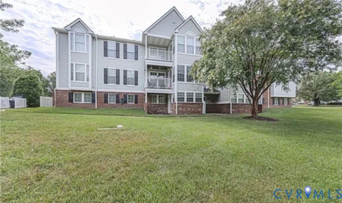 Multi-story exterior featuring a brick and siding facade, stacked private balconies, and double-hung windows with decorative shutters Multi-story exterior featuring a brick and siding facade, stacked private balconies, and double-hung windows with decorative shutters