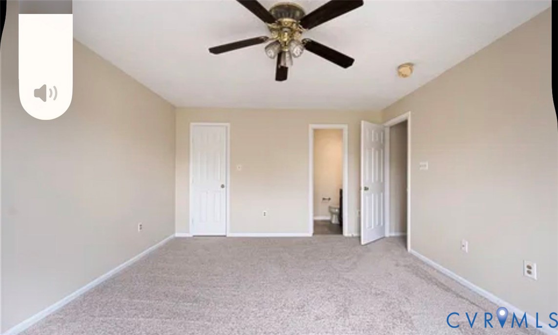 Neutral-toned interior room featuring wall-to-wall carpeting, a multi-blade ceiling fan with integrated lighting, and six-panel interior doors