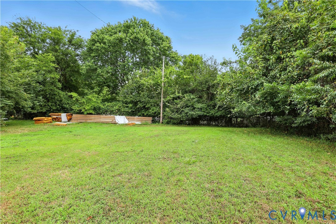 Expansive lawn area bordered by mature trees providing perimeter greenery