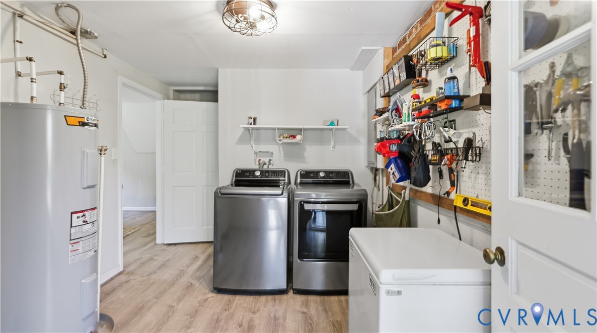 Utility room featuring wood-finish flooring, wall-mounted pegboard storage, a floating wall shelf, and an overhead flush-mount light fixture