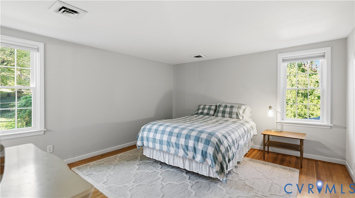 Neutral-toned interior room featuring wood-finish flooring and two double-hung windows