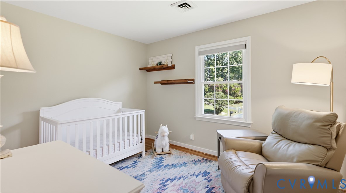 Neutral wall tones, wood-finish flooring, multi-pane window, and dual floating wood wall shelves