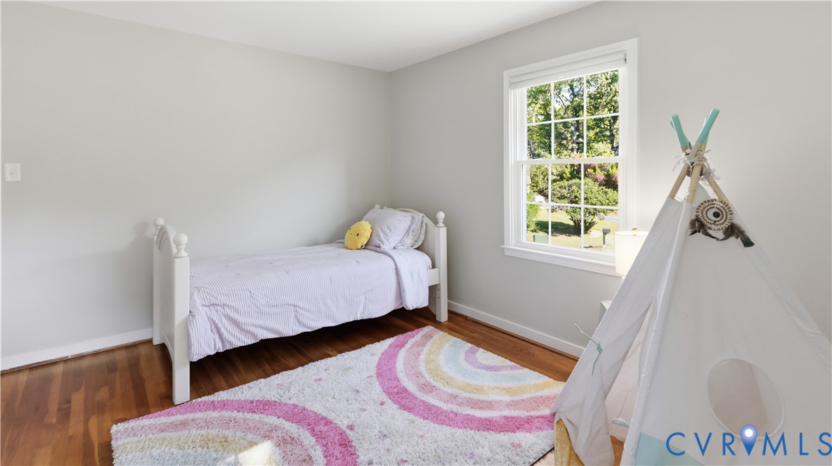 Neutral wall finishes, wood-finish flooring, and a multi-pane double-hung window