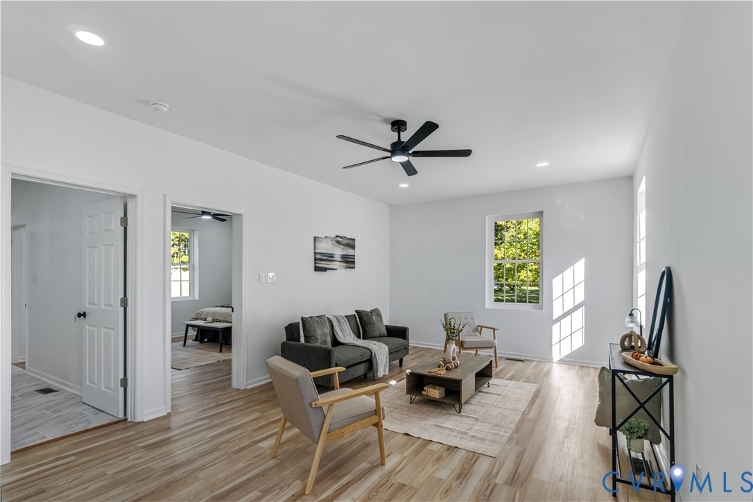 Living area featuring wood-finish flooring, recessed lighting, and a ceiling fan with integrated lighting Living area featuring wood-finish flooring, recessed lighting, and a ceiling fan with integrated lighting