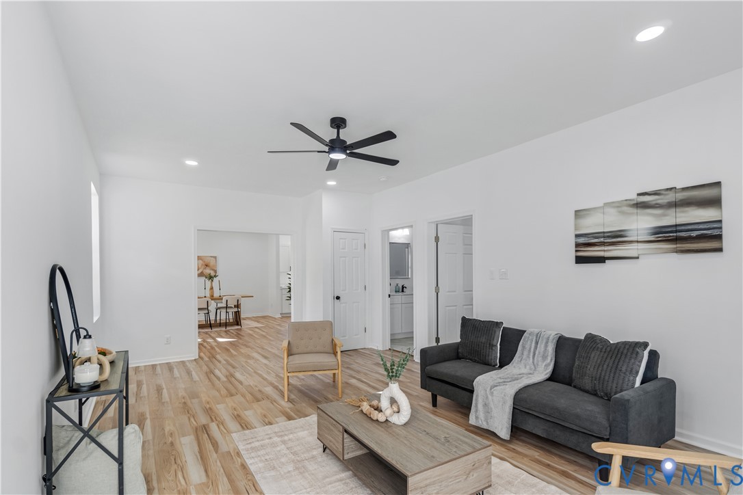 Interior space featuring wood-finish flooring, recessed lighting, and a modern black ceiling fan Interior space featuring wood-finish flooring, recessed lighting, and a modern black ceiling fan