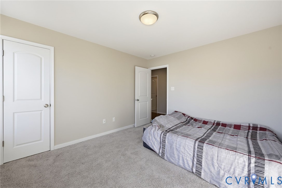 Neutral-toned room featuring neutral wall paint, wall-to-wall carpeting, flush-mount ceiling lighting, and two-panel interior doors