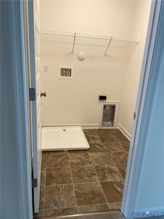 Laundry room featuring dark tile patterned flooring, hookup for a washing machine, electric dryer hookup, and hookup for a gas dryer