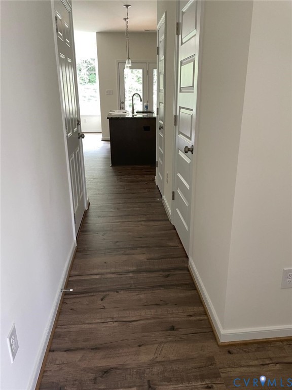 Corridor with sink and dark wood-type flooring