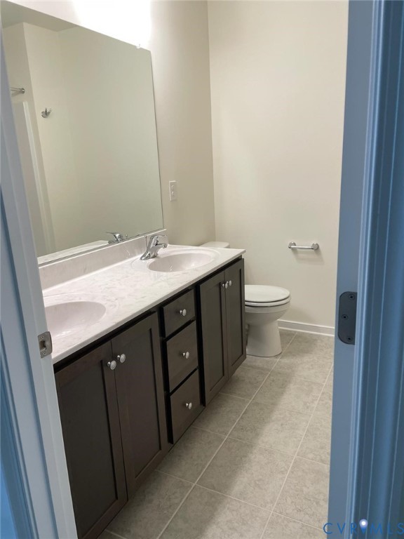 Bathroom featuring tile patterned flooring, toilet, and vanity